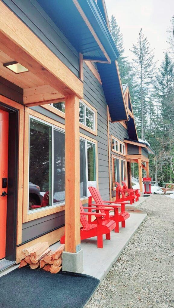 Chalet exterior with red Adirondack chairs and cedar trim